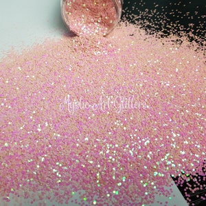 May include: Pink iridescent glitter with a pearlescent finish. The glitter is loose and scattered on a white surface.