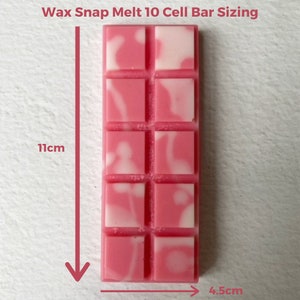 Op de afbeelding: Een roze en witte was smeltbar met 10 afzonderlijke vierkanten. De bar is 4,5 cm breed en 11 cm hoog.