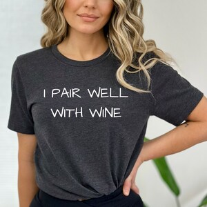 May include: A dark gray t-shirt with the text "I pair well with wine" printed in white.