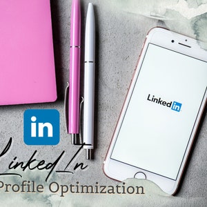 Puede incluir: Un teléfono inteligente blanco con el logotipo de LinkedIn en la pantalla. El teléfono está sobre una superficie gris texturizada con dos bolígrafos, uno rosa y uno blanco, y una pegatina azul con el logotipo de LinkedIn.