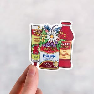 Pode incluir: Um autocolante com um ramo de flores coloridas com pétalas vermelhas, brancas e amarelas, dispostas em frente a três latas de molho de tomate italiano vermelhas e brancas. As latas são etiquetadas com "Mutti", "Polpa" e "Muttie Passata".