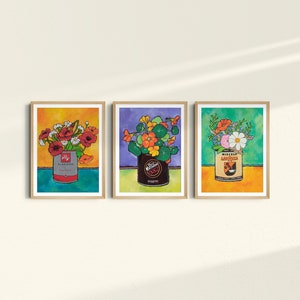 Puede incluir: Tres impresiones enmarcadas de arreglos florales en latas vintage. La primera impresi&oacute;n presenta flores rojas en una lata azul y roja etiquetada "Claussen Pickles". La segunda impresi&oacute;n presenta flores naranjas en una lata marr&oacute;n etiquetada "Wieners". La tercera impresi&oacute;n presenta flores rosas y blancas en una lata amarilla y naranja etiquetada "Miracle Whip Salad Dressing".