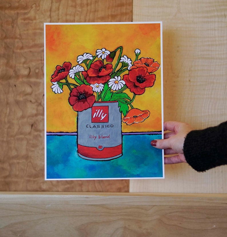 Pu&ograve; includere: Un dipinto ad acquerello di un mazzo di papaveri rossi e margherite bianche in una lattina argentata con il logo Illy Classico Illy Blend. Lo sfondo &egrave; un gradiente di giallo, arancione e blu.