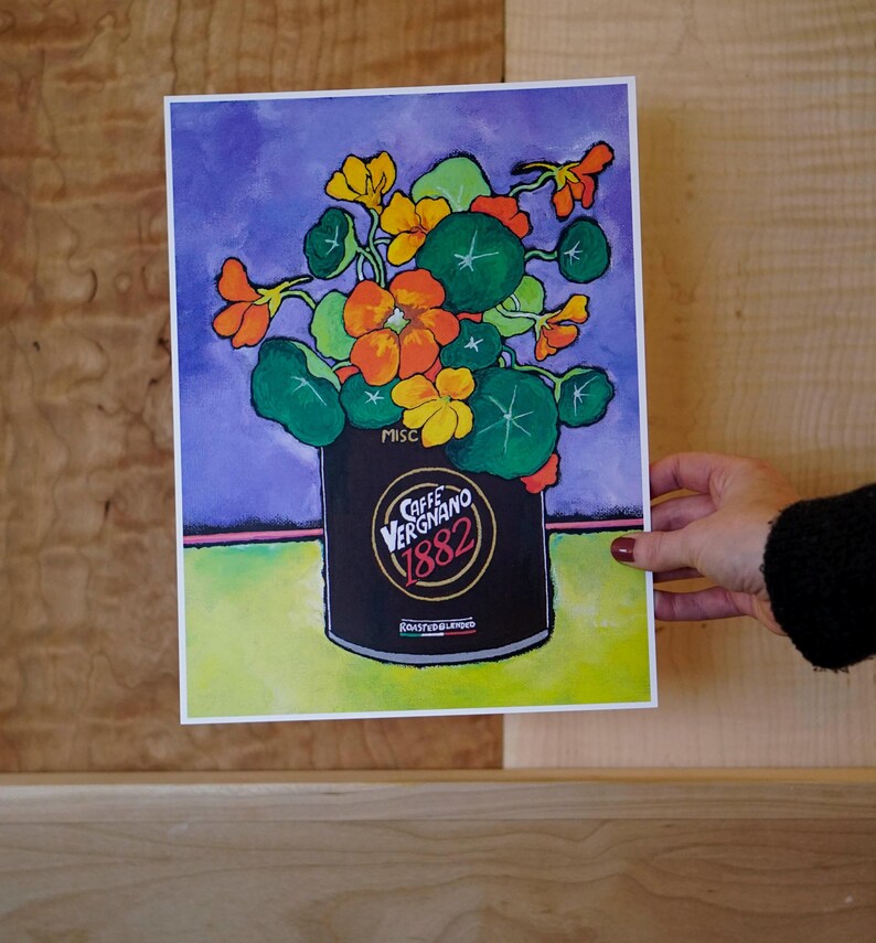 Puede incluir: Una pintura de un ramo colorido de flores naranjas y amarillas en una lata negra con el texto "Caffe Vergnano 1882" y "Roasted & Blended". El fondo es un degradado de morado y verde.