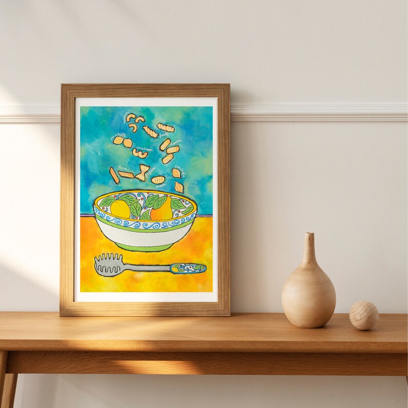 May include: A watercolour painting of a bowl of pasta with a blue and green pattern. The pasta is yellow and is flying out of the bowl. There is a yellow background and a silver pasta server on the table.