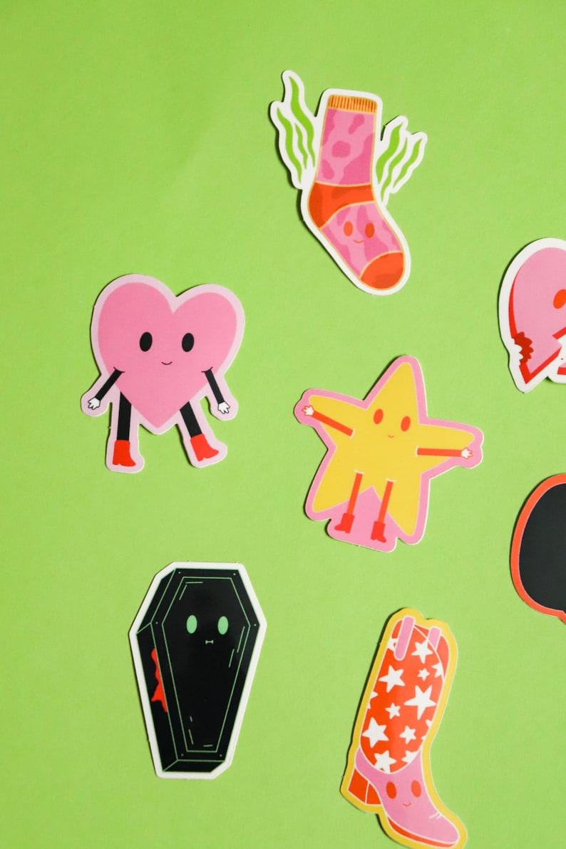 May include: A set of colorful stickers featuring a heart, a star, a boot, a sock, and a coffin. Each sticker has a cartoon face and is designed in a playful style.