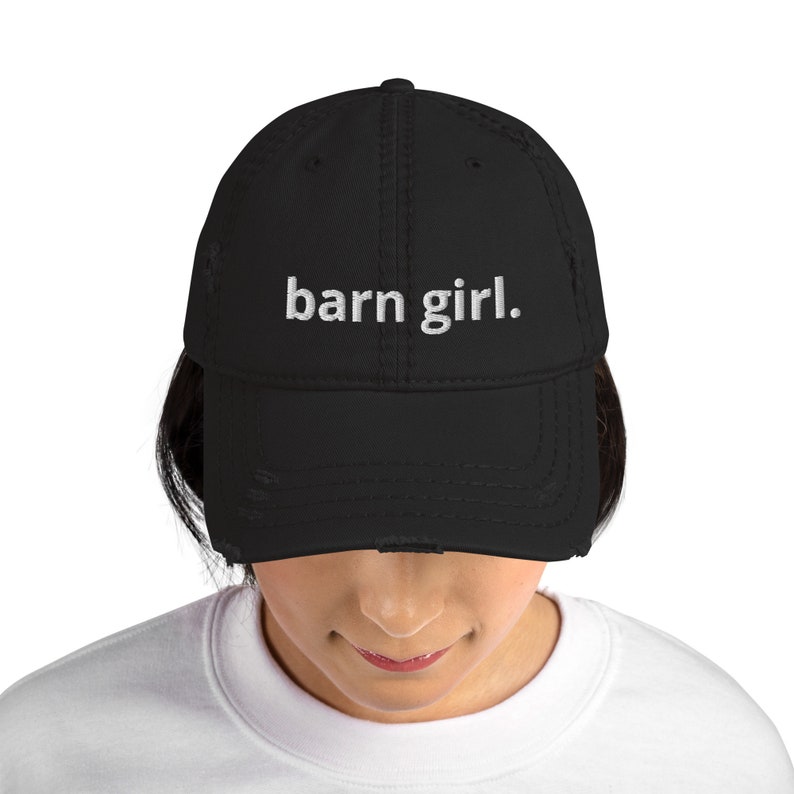May include: Black distressed baseball cap with the embroidered text "barn girl." The hat has a curved brim and a worn appearance. The cap is a classic style, suitable for casual wear.