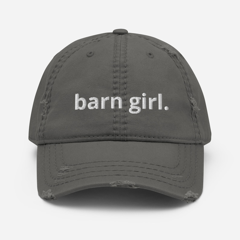 May include: A distressed gray baseball cap with the embroidered text "barn girl." The hat has a pre-worn look with distressed edges and stitching details. A casual accessory for everyday wear.