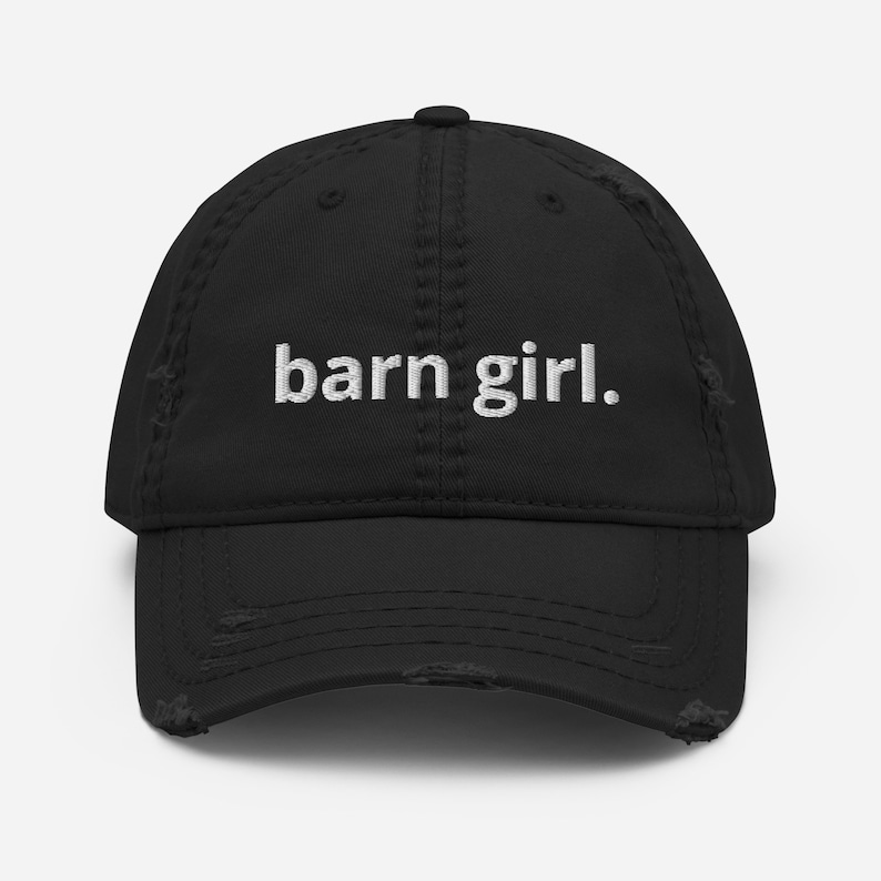 May include: Black distressed baseball cap with the embroidered text "barn girl." The cap has a curved brim and a worn, vintage look. The text is in a white, sans-serif font.