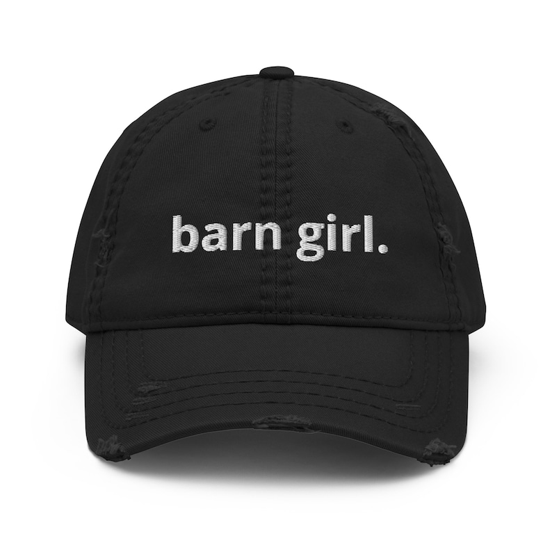 May include: Black distressed baseball cap with the embroidered text "barn girl." The cap has a curved brim and a distressed, worn look.