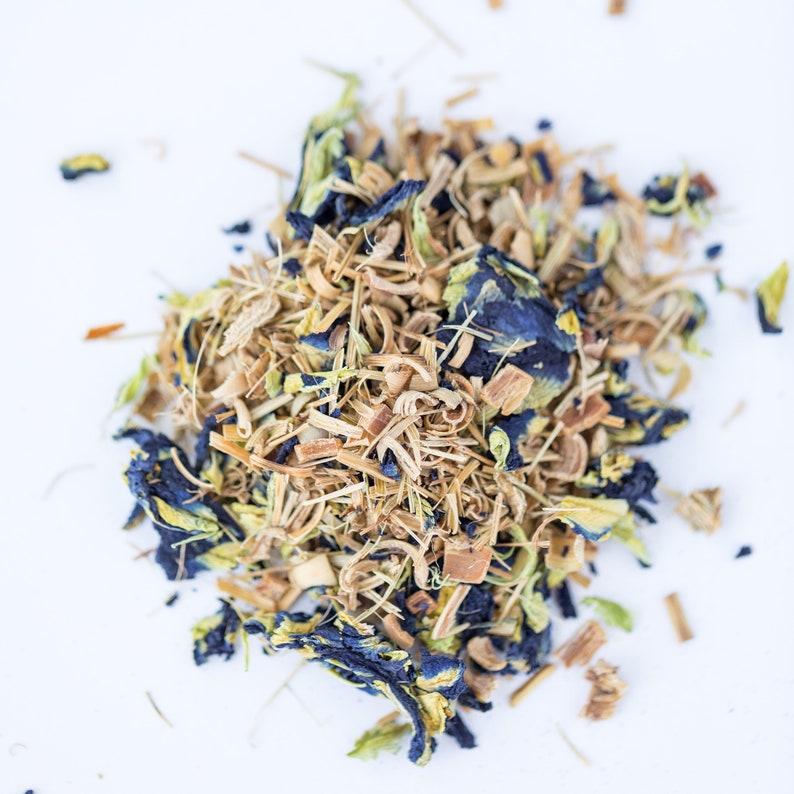 May include: A close-up of a blend of dried herbs and flowers for tea. The mix includes dried lemongrass, blue pea flowers, and other herbs.