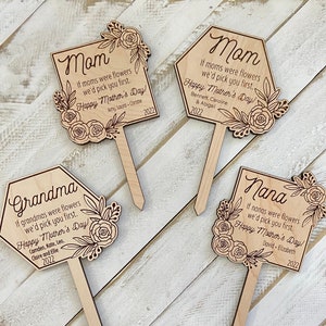 May include: Four wooden signs with floral designs and the words "Mom", "Grandma", "Mom", and "Nana". Each sign has a personalized message for Mother's Day, including the names of the children and the year 2022.
