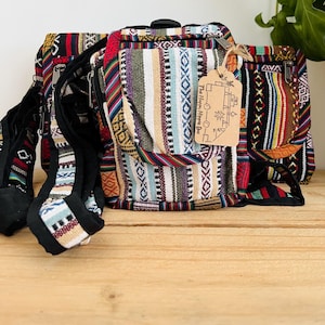 May include: A set of three colorful woven bags with a black strap and a tag that reads "The Happy Hippie Bus" and "コー○ー○ーロ".