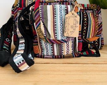 Pode incluir: Um conjunto de três bolsas tecidas coloridas com uma alça preta e uma etiqueta que diz "The Happy Hippie Bus" e "コー○ー○ーロ".