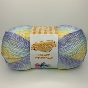 Può includere: Un gomitolo di filato Lion Brand Ice Cream Roving Divagation in un degradé di blu, giallo e verde.