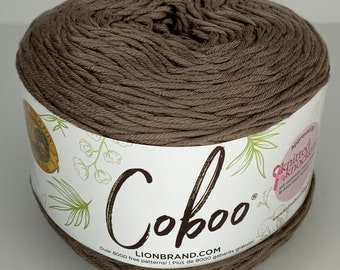 May include: A skein of brown Coboo yarn, a Lion Brand yarn, with the brand name and website printed on the label. The label also says "Over 8000 free patterns!"