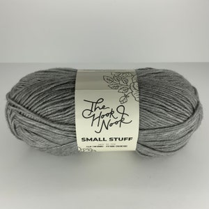 May include: A skein of gray yarn labeled "The Hook Nook Small Stuff yarn - 4 oz (100 grams) - 270 yards (250 meters)"