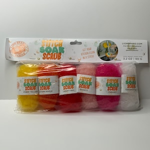 Puede incluir: Un juego de seis estropajos de cocina coloridos con las palabras "Stitch Soak Scrub" en cada uno. Los estropajos son de color amarillo cibernético, arce de otoño, rojo amapola, cuarzo, cabaret y coco.