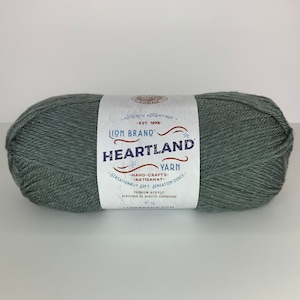 May include: A skein of Lion Brand Heartland yarn in a light green color. The label reads "Lion Brand Heartland Yarn" and "Sensationaly Soft - Sensation Douce".