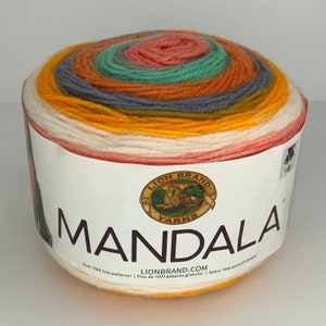 May include: A ball of Lion Brand Mandala yarn in the colorway "Sunrise" with a white background and the text "LION BRAND YARNS MANDALA Over 2000 free patterns! Plus de 2000 gabarits gratuits! / Sobre 7000 patronos gratis! LIONBRAND.COM"