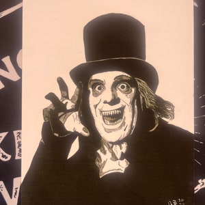 May include: A black and white illustration of a man with a top hat and a sinister smile. The man is wearing a dark suit and has long, dark hair. The illustration is done in a vintage style.