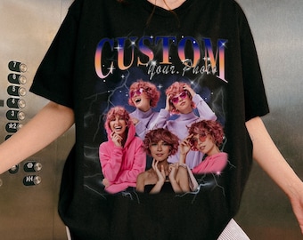 May include: Black t-shirt with a graphic print of a woman with pink hair in multiple poses. The graphic includes the text "CUSTOM Your Photo" with a sunset gradient background.