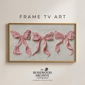 May include: A framed artwork with three textured pink bows on a white background. The bows have long, flowing ribbons and are set against a textured, off-white backdrop. The frame is gold. Text at the top reads "FRAME TV ART".
