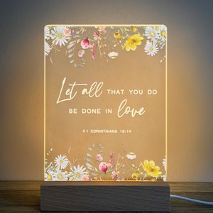 May include: A white light-up sign with a floral border and the text "Let all that you do be done in love 1 Corinthians 16:14".
