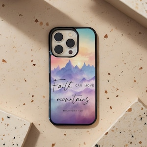 Peut inclure: Coque de téléphone noire avec un paysage de montagne coloré. Elle porte l'inscription "Faith can move mountains" et le verset biblique Matthieu 17:20. Le fond présente un dégradé de bleu, de rose et d'orange.