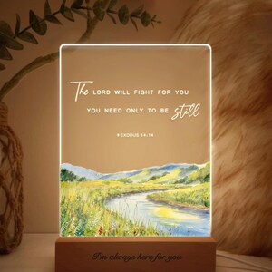 May include: A white LED light with a watercolour landscape scene and the text "The Lord will fight for you, you need only to be still. Exodus 14:14" and "I'm always here for you".