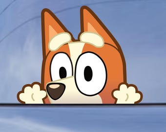 May include: A vinyl decal sticker featuring a cartoon dog character with orange and cream fur, large white eyes, and two paws visible at the bottom, applied to the rear window of a dark-colored vehicle.