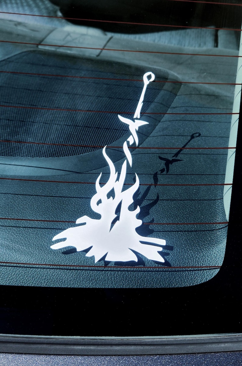 May include: A white vinyl decal of a sword in a bonfire, a popular symbol from the video game Dark Souls.
