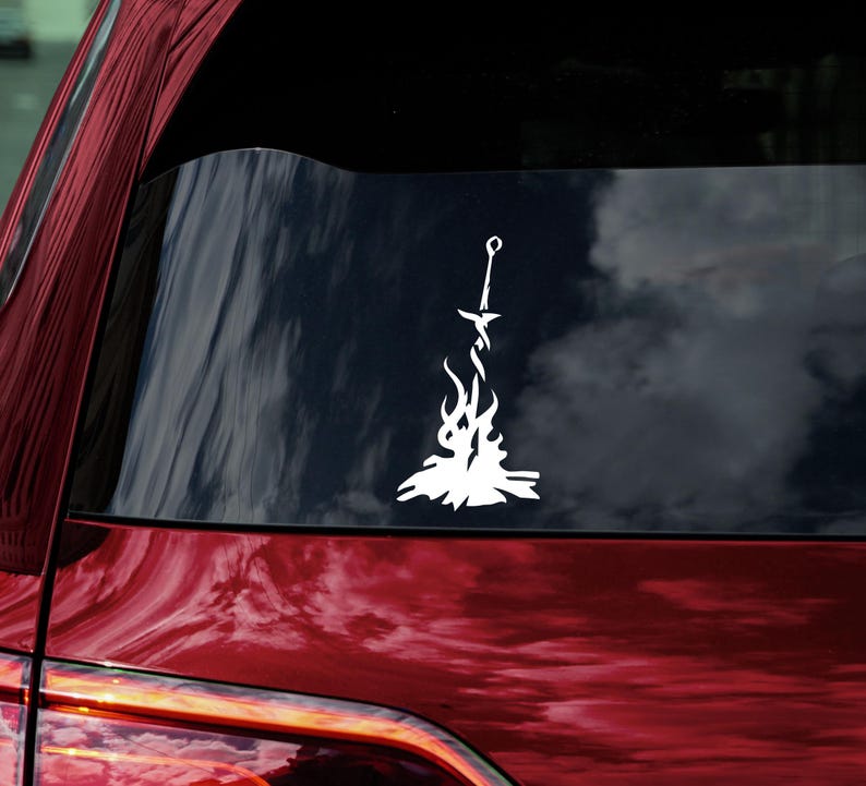 May include: White vinyl decal of a sword in a bonfire, a popular symbol from the video game Dark Souls.