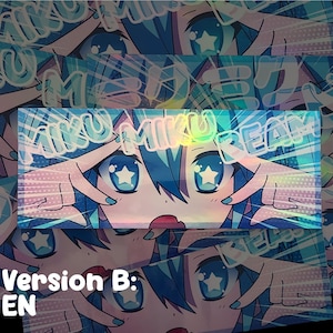 May include: Holographic sticker featuring a stylized anime character with blue hair and large blue eyes with star-shaped pupils. The text "MIKU MIKU DREAM" is overlaid. The sticker has a Version B: EN label.