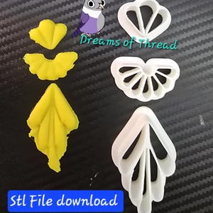 以下が含まれることがあります： 3つの白いプラスチック製クッキー型と、それに対応する黄色の成形品。クッキー型は扇形、花びら、葉のようなデザインが特徴です。画像には鳥のイラスト、Dreams of Threadという文字、Stl File downloadという文字が含まれています。