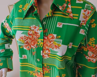 1970年代風レトロディスコシャツ。ケリーグリーン、オレンジ、イエローの配色、大きなディスコカラー、レディースSサイズ、花柄。ヒッピー風、ポリエステル製。