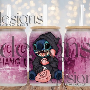 Puede incluir: Tres vasos de vidrio con tapas de bambú y pajitas. Cada vaso presenta un diseño único: uno con el texto "NO YOU HANG UP", otro con un personaje de dibujos animados sosteniendo un teléfono y el último con un diseño de huella de mano. Los vasos tienen un fondo rosa.