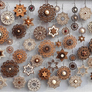 Puede incluir: Una colección de pendientes de madera con diseños intrincados en varias formas, incluyendo estrellas, flores y patrones circulares. Los pendientes son en tonos marrones y beige, algunos con acentos de perlas, y se exhiben sobre un fondo de malla.