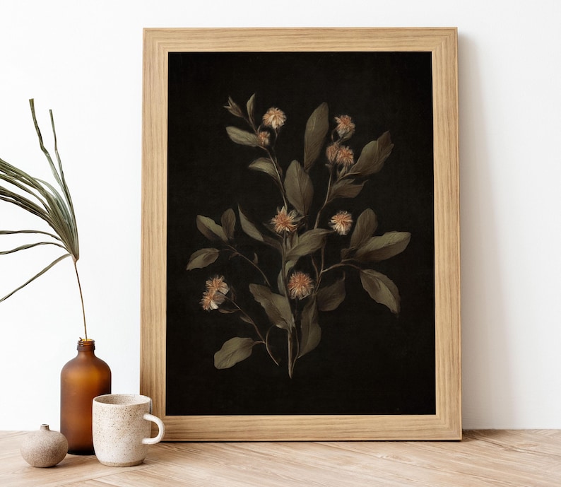K&ouml;nnte beinhalten: Ein gerahmter botanischer Druck mit einem zarten Zweig wei&szlig;er Bl&uuml;ten mit gr&uuml;nen Bl&auml;ttern vor schwarzem Hintergrund.