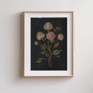 May include: A framed botanical print featuring a cluster of light pink and white flowers with green leaves against a dark navy background. The artwork is encased in a thin, light-colored wooden frame.