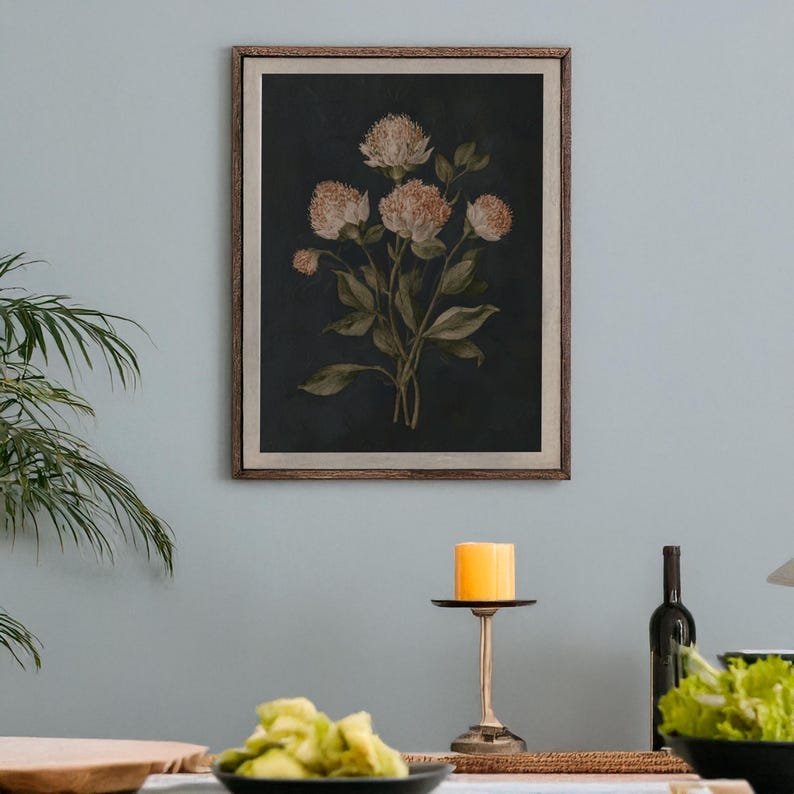 May include: A framed botanical print featuring a cluster of flowers with light peach-colored blooms and green leaves against a dark background. The artwork is in a wooden frame, adding a touch of rustic charm to the floral arrangement.