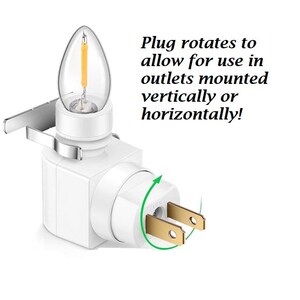 May include: A white night light with a clear, candle-shaped bulb and a rotating plug. The plug rotates to allow use in outlets mounted vertically or horizontally.