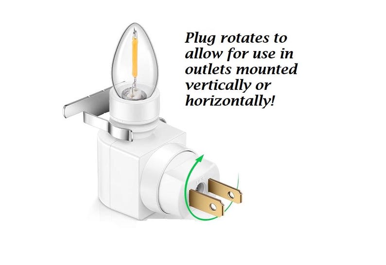 May include: A white night light with a clear, candle-shaped bulb and a rotating plug. The plug rotates to allow use in outlets mounted vertically or horizontally.