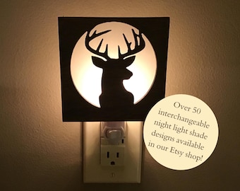 May include: A wooden night light with a deer silhouette in a circle. The light is plugged into an outlet. Over 50 interchangeable night light shade designs are available in our Etsy shop!