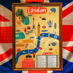 May include: A colourful illustrated map of London, England, with points of interest highlighted. The map features landmarks like Big Ben, Buckingham Palace, and Tower Bridge. The map is in a wooden frame and has a scratch-off finish.