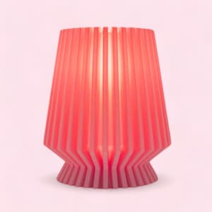 May include: A pink lamp with a pleated shade and a geometric base.