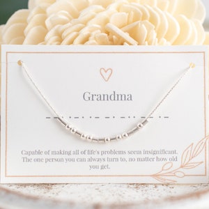 Puede incluir: Una tarjeta blanca con un collar plateado encima. La tarjeta dice "Abuela" y tiene una cita sobre cómo las abuelas siempre están ahí para ti.