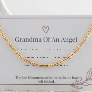 May include: Gold beaded necklace with a card that reads "Grandma Of An Angel" and "The loss is immeasurable, but so is the love left behind."