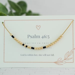 May include: A gold beaded bracelet with black beads and a card that reads "Psalm 46:5 God is within her, she will not fall."
