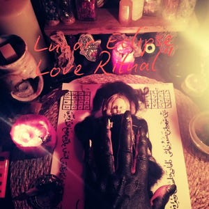 May include: An image of a ritual setup with candles, a doll, and a hand covered in black paint. The text "Luna Eclipse Love Ritual" is written in pink. The Etsy shop name "Anatoliaspell.etsy.com" is also visible.